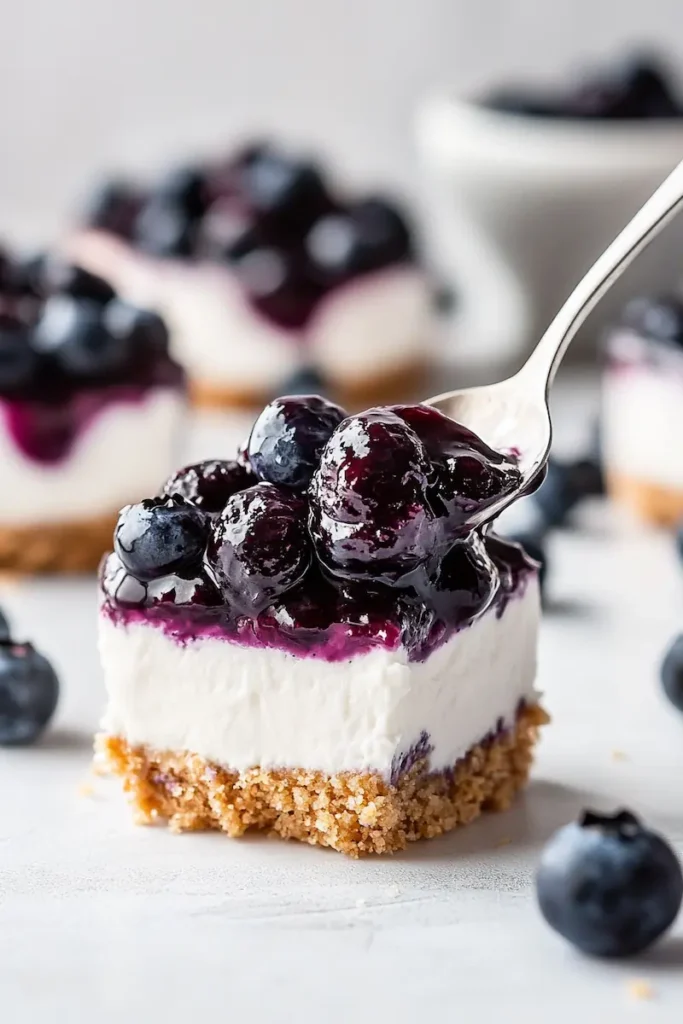 No-Bake Blueberry Cheesecake Cups (Easy & Creamy) 2 Close-up of a spoonful of no-bake blueberry cheesecake cup showing creamy filling and blueberry topping