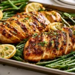 One Pan Chicken and Green Beans Roasted one pan chicken and green beans served on a sheet pan with lemon slices in a cozy evening kitchen