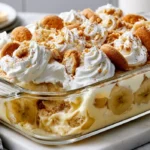 Creamy banana pudding made the night before with banana slices, vanilla wafers, and whipped topping in a glass dish.
