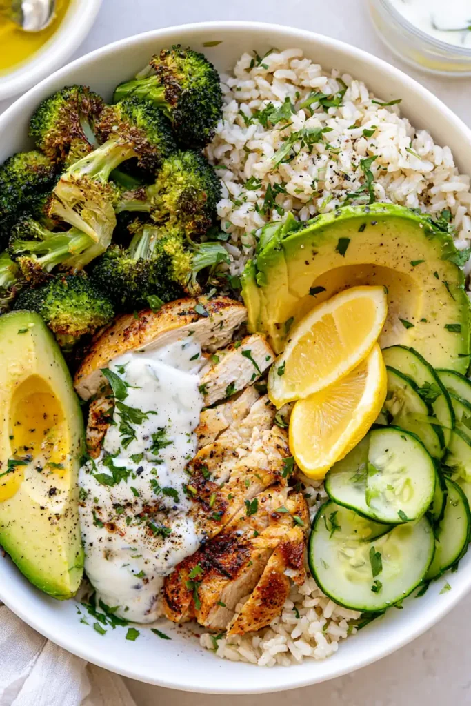What Can I Make for Dinner with Chicken and Broccoli? 3 Healthy chicken rice bowl with roasted broccoli, avocado, cucumber, and lemon yogurt sauce